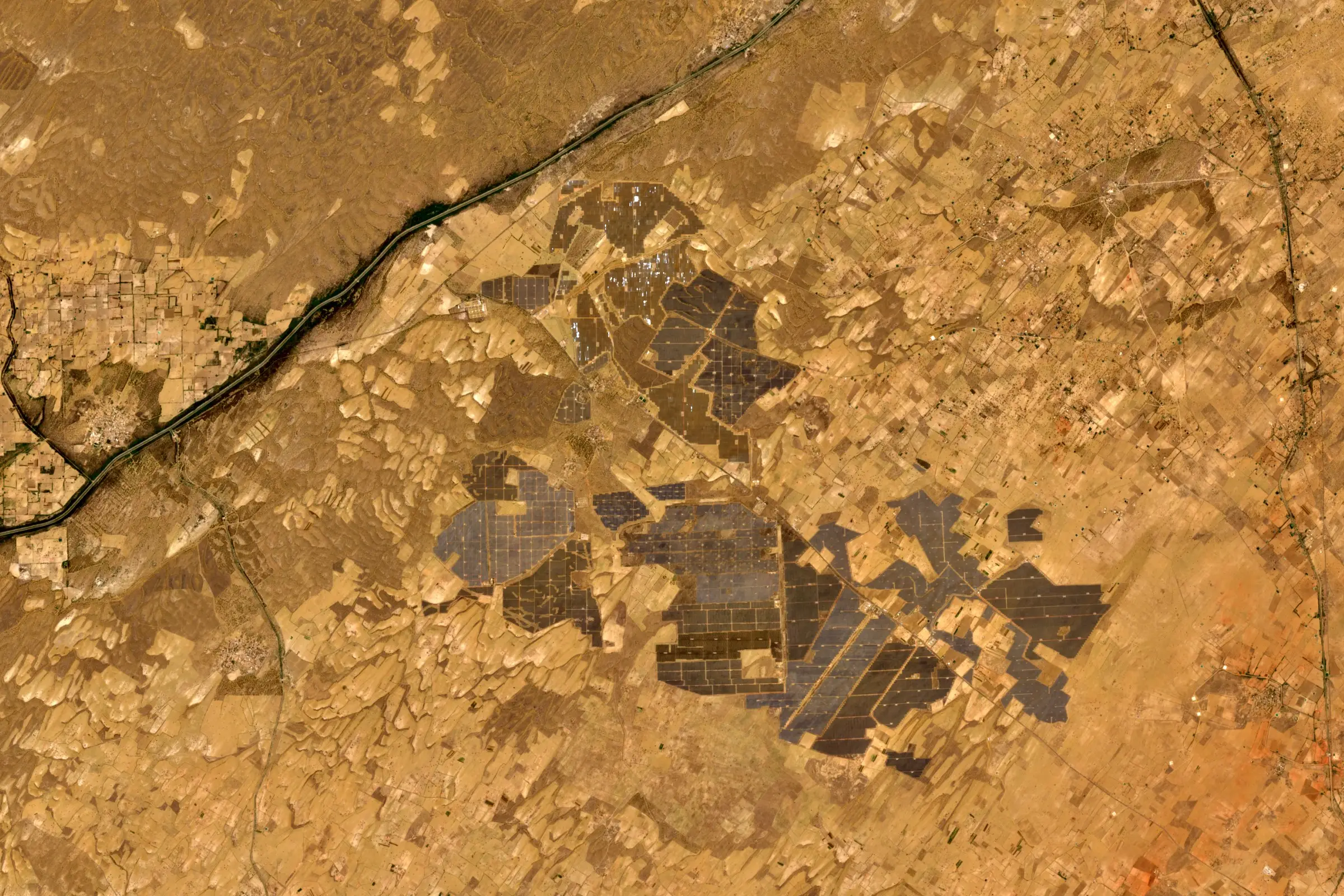 Satellite view of the grey rectangular arrays of a large solar park in the Rajasthan desert