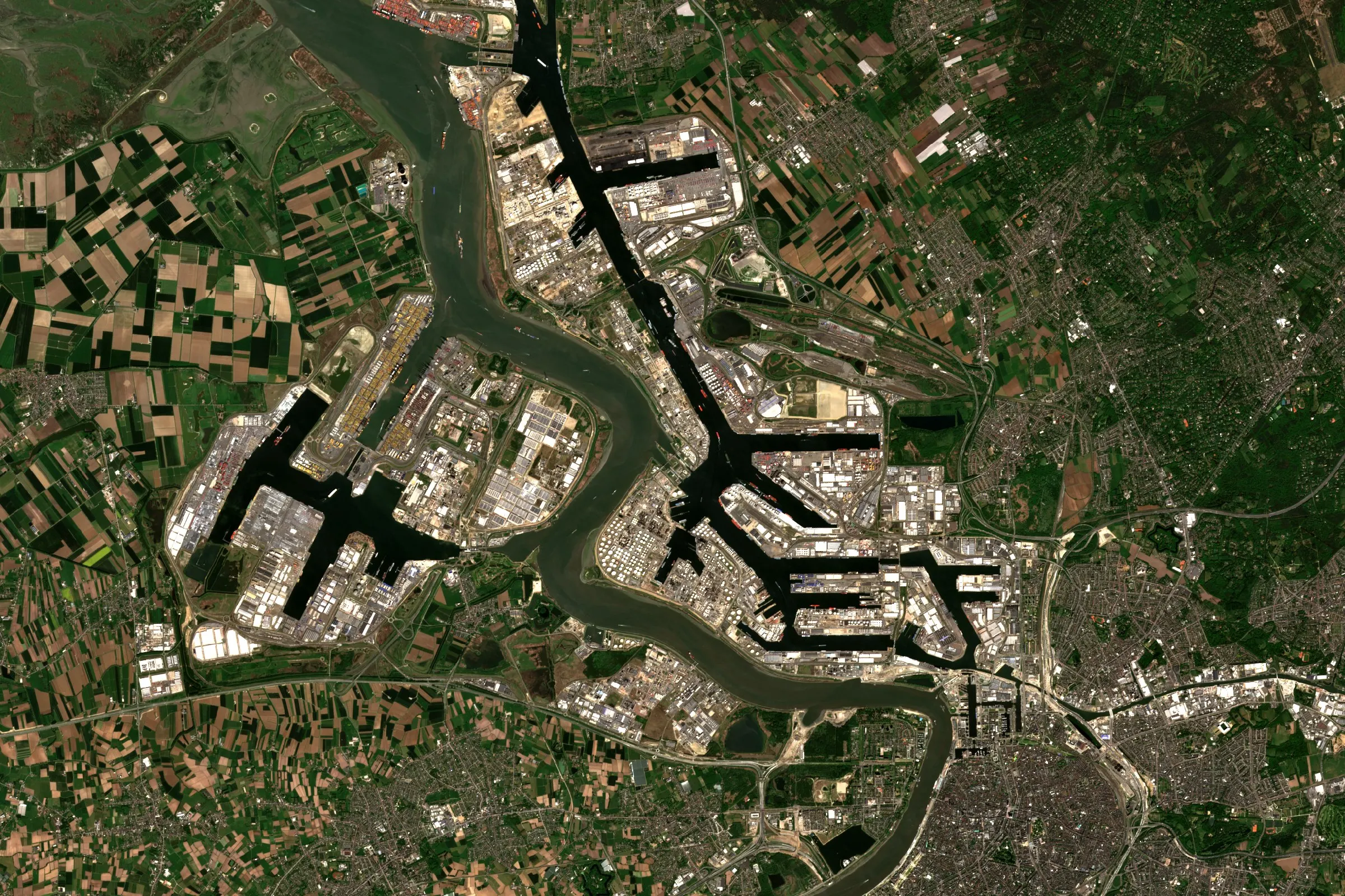 Satellite view of the Port of Antwerp, with docks and container terminals along the Scheldt and farmland around them