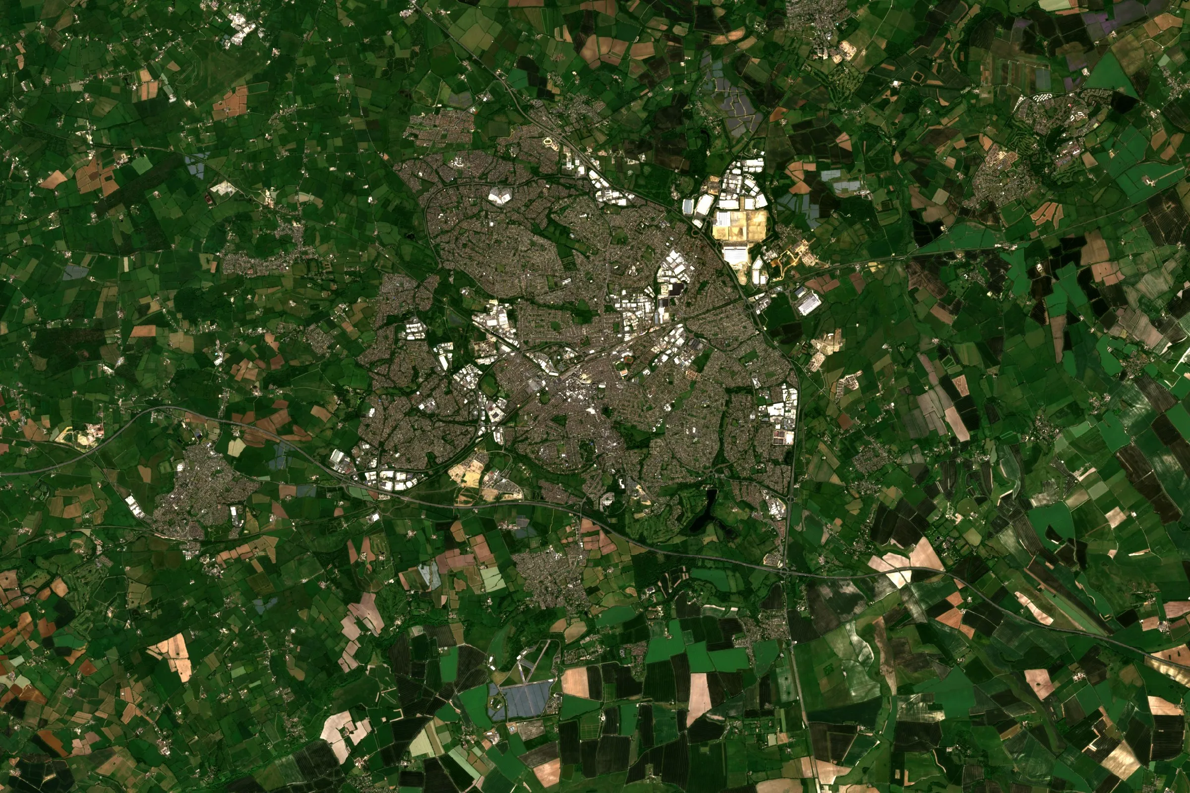 Satellite view of Swindon, Wiltshire, with the town at the centre ringed by green and brown farmland